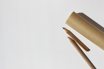 Graphite Pencils, Brown Paper Roll on White Paper Background. Sketching Mockup. Design Studio.