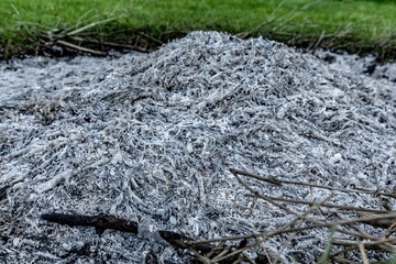 A close-up view of a pile of ashes, remnants of a fire, with intricate textures and tones, representing transformation and renewal.
