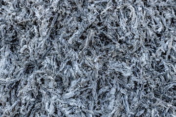 A close-up view of a pile of ashes, remnants of a fire, with intricate textures and tones,...