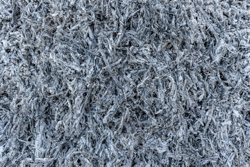 A close-up view of a pile of ashes, remnants of a fire, with intricate textures and tones, representing transformation and renewal.