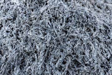 A close-up view of a pile of ashes, remnants of a fire, with intricate textures and tones, representing transformation and renewal.
