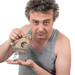 A shaggy, gray-haired, unshaven middle-aged man in a sleeveless T-shirt holds in his hands a...