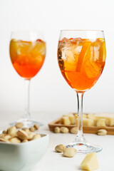 Happy hour with Aperol Spritz served with an orange slice in wine glasses. White wooden table, high key, high resolution