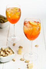 Happy hour with Aperol Spritz served with an orange slice in wine glasses. White wooden table, high key, high resolution
