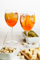 Happy hour with Aperol Spritz served with an orange slice in wine glasses. White wooden table, high key, high resolution