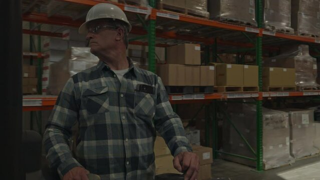Tracking shot of worker driving forklift in warehouse / American Fork, Utah, United States