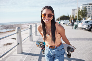 Happy, portrait and woman by ocean with skateboard for weekend, holiday and vacation in trendy...