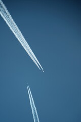 two parallel airplane tracks in the blue sky, contrails