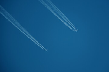 two parallel airplane tracks in the blue sky, contrails