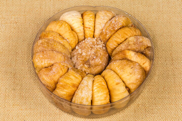 Dried figs in open round plastic packaging on textile napkin