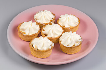 Small fruit tarts with custard top on pink dish
