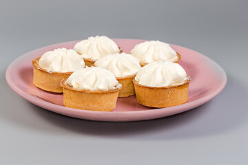 Small tarts with custard top on pink dish, side view