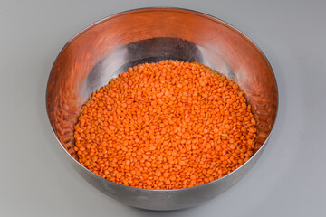 Raw whole red lentil in the stainless steel kitchen bowl