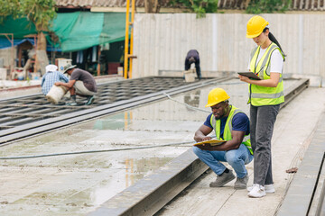 Engineer smart women working contact with African black worker in Precast concrete casting manufacturing company site inspector