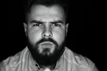 Close-up portrait of a man with a beard in a white shirt. Grain effect used