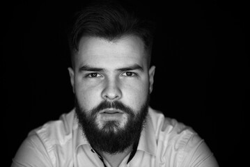 Close-up portrait of a man with a beard in a white shirt. Grain effect used