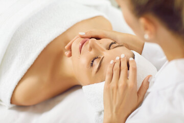 Beauty treatment skincare. Satisfied beautiful woman receiving facial treatment and professional...