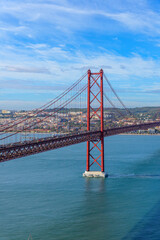 photo of the cityscape of Lisbon and the 25 April red bridge over the Tagus river on a sunny day