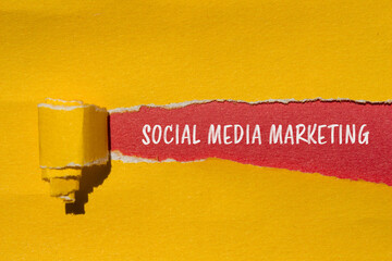 Social media marketing words written on ripped yellow paper with red background. Conceptual social...
