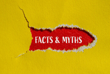 Facts and myths words written on ripped yellow paper with red background. Conceptual facts and...