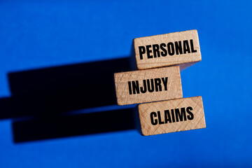 Personal injury claims written on wooden blocks with blue background. Conceptual personal injury...