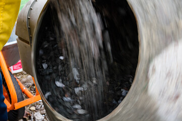Preparing concrete in cement mixer for pouring foundation of the building