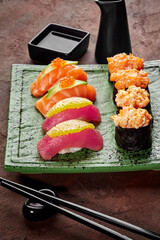 Elegant nigiri and gunkan sushi set on textured green plate
