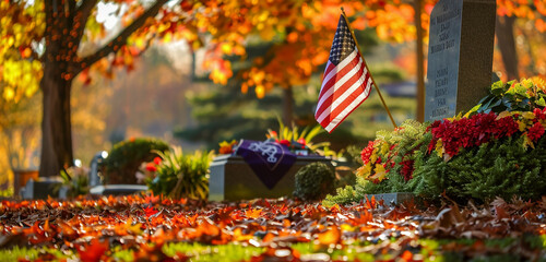 Memorial Day flag and autumn foliage at a veteran's grave, seasonal warmth.