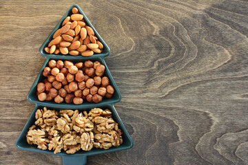 a plate of nuts. Various snacks for the New Year's table in a plate in the shape of a Christmas tree