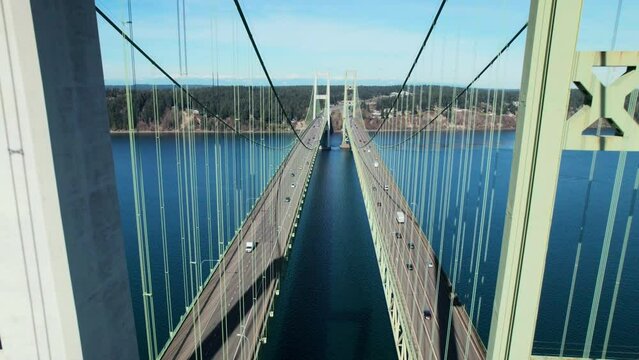 Drone Shot Between Bridge Pillars with Cars Crossing Blue Water