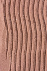 Lines drawn in brown sand background, beautiful sand texture, overhead view of chocolate brown sand, zen pattern drawn in the sand, Top view of fine grain texture