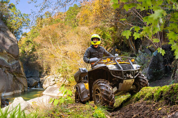 Man on ATV in mountains. Guy on quad bike. Off-road driving. Quad biker loves extreme sports. Male...