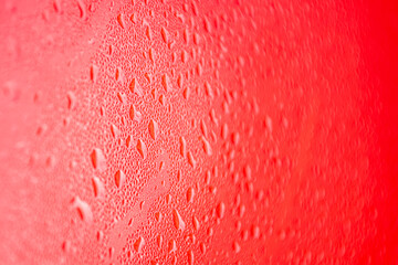 Water drops on red background. Water droplets on the glass.