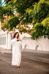 Woman city blanket. Morning in the big city. A blonde woman in a white blanket is enjoying in the...