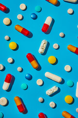 A blue background with many pills and capsules.