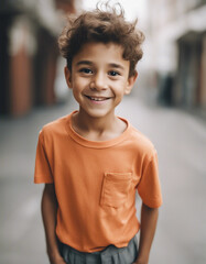 Portrait of a smiling boy in a orange t-shirt on a white background
