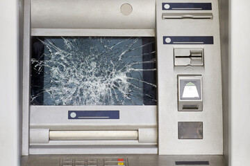 Broken glass screen ATM on city street. Close-up.