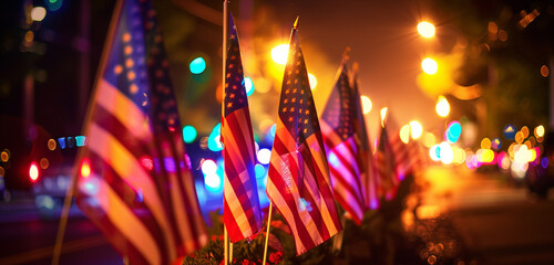 Vibrant lighting highlights flags waving in the night during a Veterans Day parade.