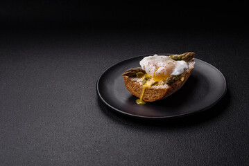 Delicious hearty breakfast consisting of poached eggs on toast with cream cheese, asparagus