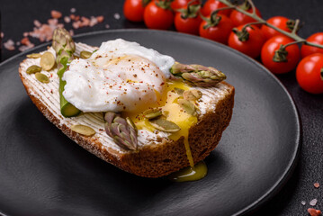 Delicious hearty breakfast consisting of poached eggs on toast with cream cheese, asparagus
