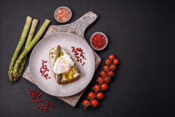 Delicious hearty breakfast consisting of poached eggs on toast with cream cheese, asparagus