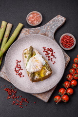 Delicious hearty breakfast consisting of poached eggs on toast with cream cheese, asparagus