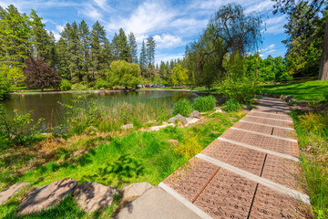 The landscaped gardens surrounding Mirror Pond at the public Manito Park and Botanical Gardens in the South Hill downtown district of Spokane, Washington.
