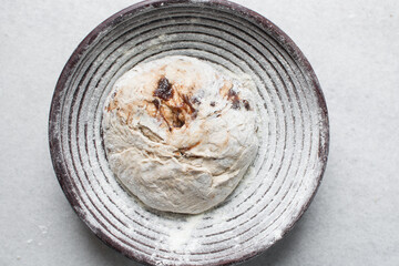 Overhead view of bread dough filled with date jam rising in banneton basket , top view of proofing...