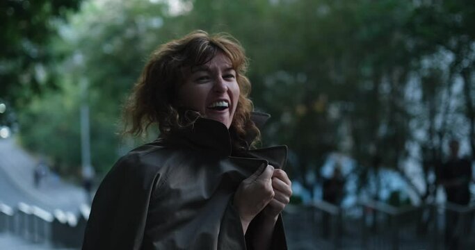 Smiling laughing of caucasian woman happy in a city urban view. Female person or model outdoor with making fooling or making laugh concept