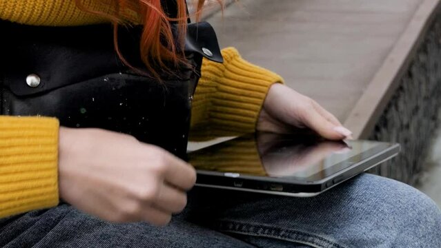 The girl connects a flash drive to her tablet