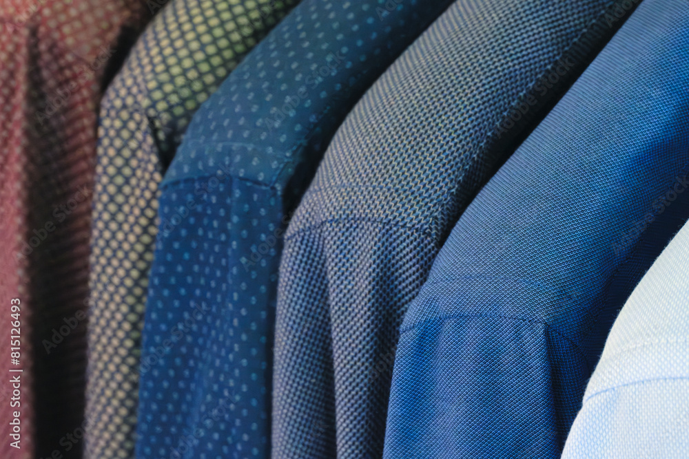 Poster a row of shirts with different colors and patterns hanging on a clothesline. the shirts are neatly f
