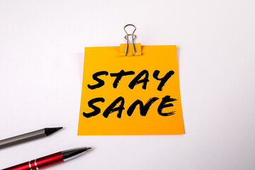 Stay Sane Concept. A yellow notepad on a white office table