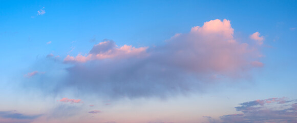 A large cloud in the sky with a pinkish hue. The sky is clear and blue