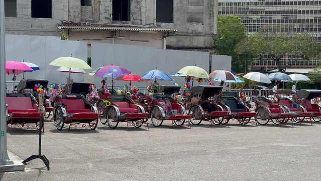 Trishaw bikes for public and tourist transport standing empty in front of the International Cruise Terminal, George Town, Penang, Malaysia